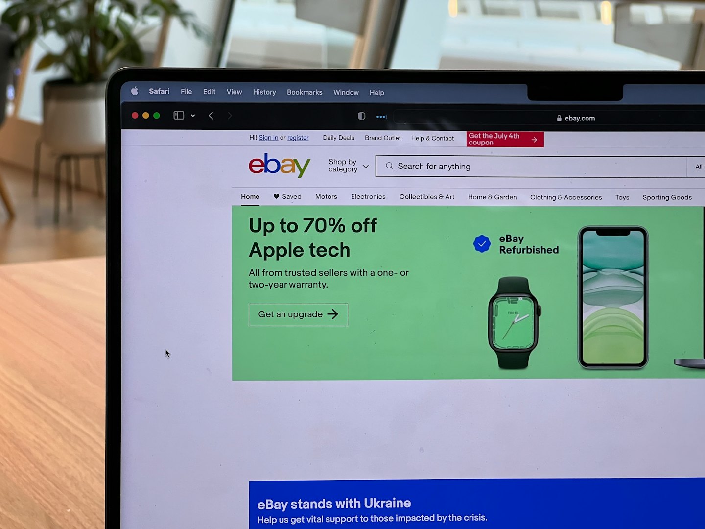 Laptop screen showing eBay website homepage on a table.